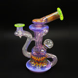 Andy G glass recycler in purple with UV reversal line work, a clear marble on the side and a wig-wag band around the base