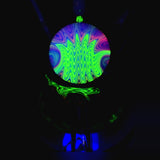 The marble and the body of the recycler under a UV light against a black backdrop