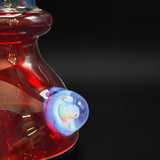 Close up of the opal marble set into the red shoulder of the Arko Glass mini tube