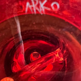 Arko's signature scratched into the red foot of the mini tube, seen through the base
