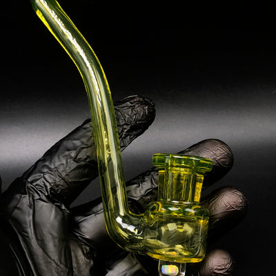 Miyagi G Drylock V1 held in a gloved hand, fumed yellow-green glass with a long curved neck.