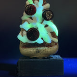 The pizza Pivot top under blacklight, the UV reactive glass glowing, on its stand