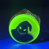 Close-up of the Oogie Boogie millie on the @fun_king_glass Pivot top, shown under blacklight with the top glowing green