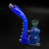 The gummy bear Sherlock from the side, the stem curving up to the left of the bear