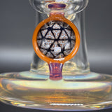 Close up of the sacred geometry millie in its orange surround, above the thick foot