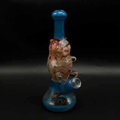 Gonzo Glass Works gummy bear tube standing upright, blue base and neck with a cream, red and orange wrap-and-rake body.