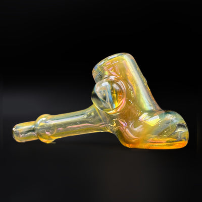 Fumed glass hammer pipe by @itsnotawaterpipe, gold and silver fume, three-quarter view showing the can, the marble and the stem