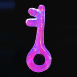 The UV Pink (Lucy) glass key pendant by PyroVibe under a blacklight, glowing hot pink