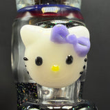 Close-up of a sculpted white cat face with a purple bow inside the tube