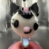 Close-up of a sculpted character with black ears and a pink nose at the base of the tube