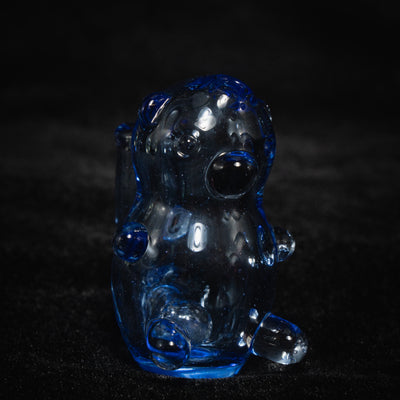 Gonzo Glass Works UV gummy bear rig in clear and blue glass, seated bear form on black velvet.