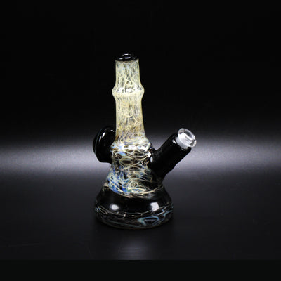 Wil Glass Particle Collider mini tube, silver stringers through a black jack fade, side view showing the 14mm joint
