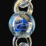 The middle particle collider attachment, blue under clear glass, set between two chain links