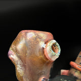 Close-up of the top of the can, the small ringed opening on the side of the sculpted glass