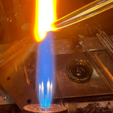 A glass rod glowing orange in the torch flame at the High Tide Santa Barbara studio, where the Intro to sculpting class is taught